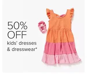 Image of an orange and pink dress and pink scrunchies. 50% off kids' dresses and dresswear.