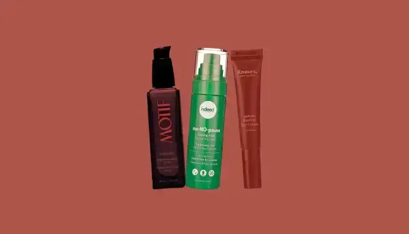 Best Menopause Skin Care: Bottles of skin-care serums from Motif, Indeed, and Knours on a dark red background.