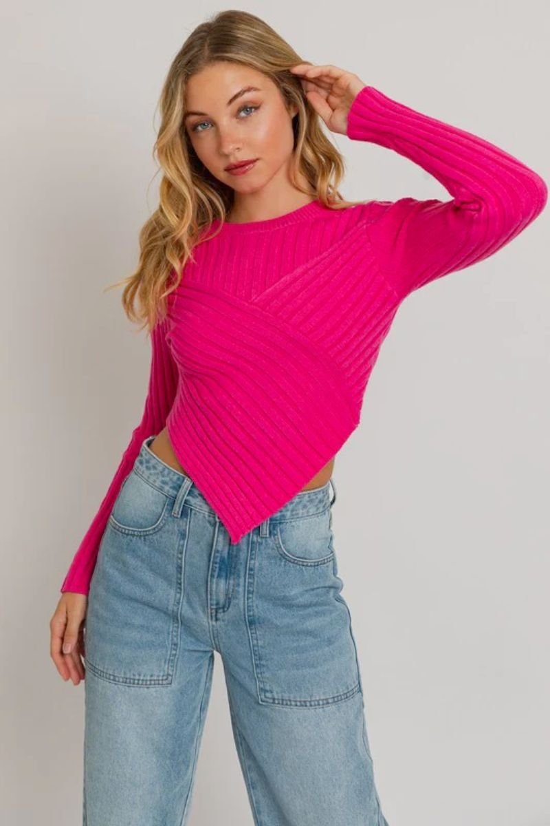 Asymmetrical Hem Sweater Top. The model is wearing a fuchsia sweater with blue jeans. She has blonde hair.