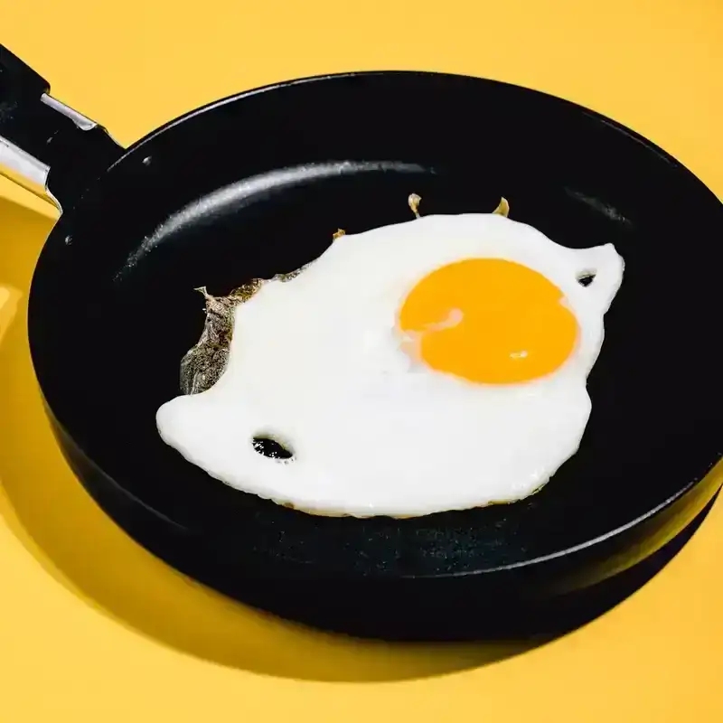 fried egg on black pan. top view photography. hen egg, breakfast food.