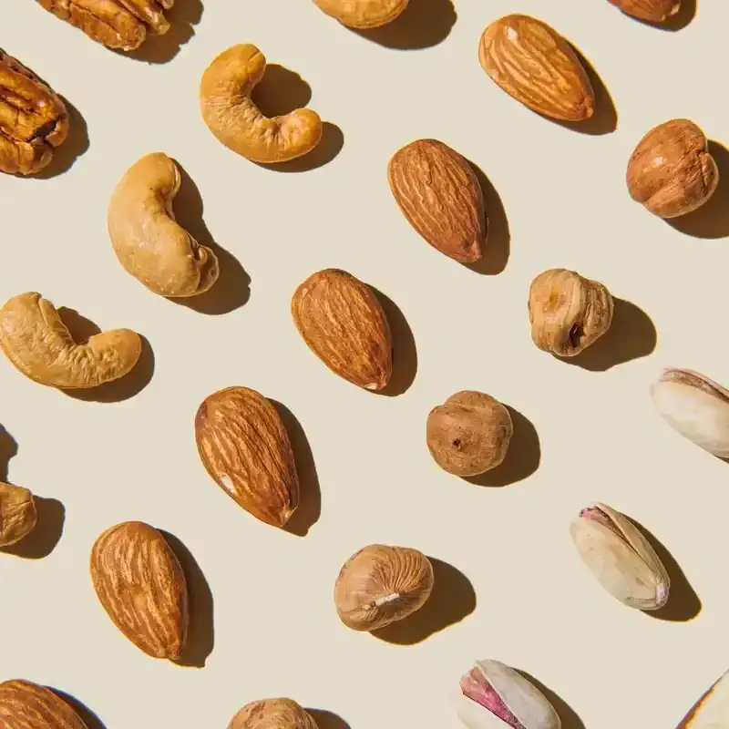 Pattern of various nuts on beige. Healthy eating concept. Pecan, brazil nut, almonds, hazelnuts, pistachios, cashews. Top view, flat lay.