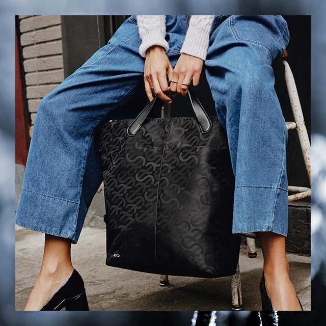 Woman holding black tote