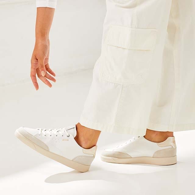 Woman wearing white outfit with white sneakers