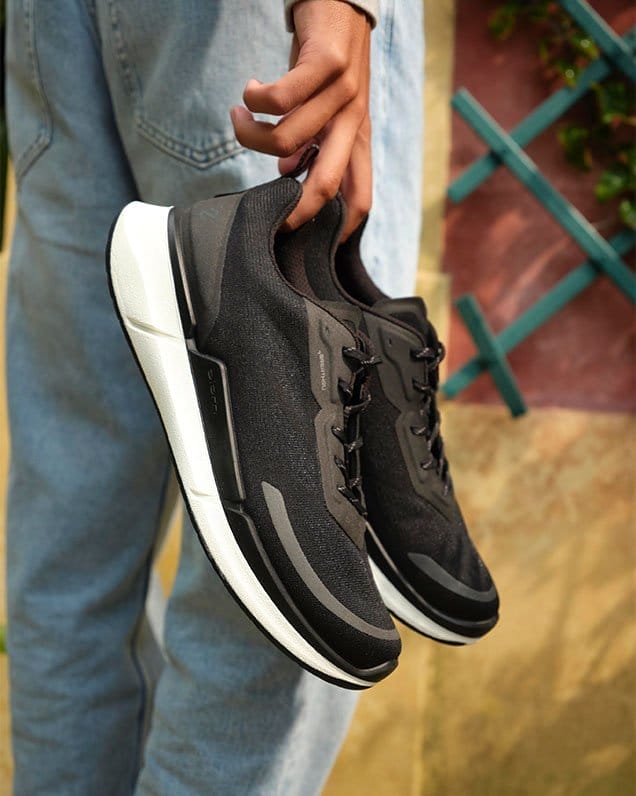 Man holding black sneakers