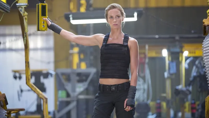 Image may contain: Emily Blunt, Person, Accessories, Belt, Clothing, Pants, Worker, Glove, Head, and Face