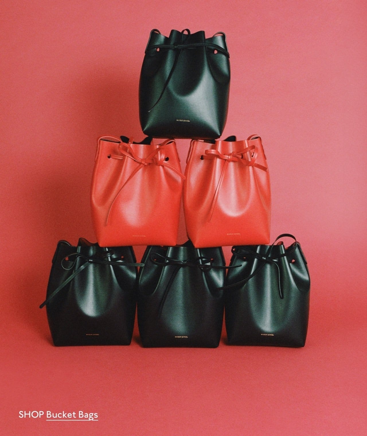 Shop iconic buckets. Pictured: the Mini Bucket Bag in Black/Flamma and Poppy.