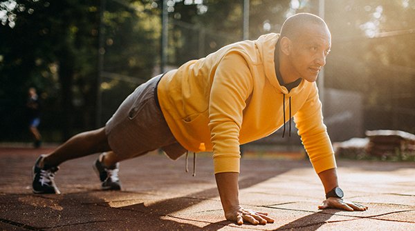 Man doing a push-up outside on pavement