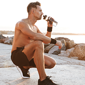 man sitting outside drinking water