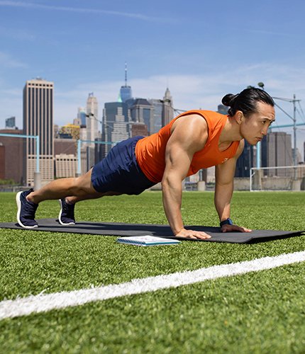 Man outside on yoga mat doing a plank