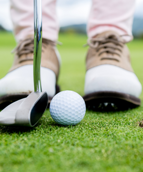 shoes on green with golf ball