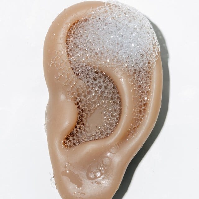 A fake ear with soap suds on it. 