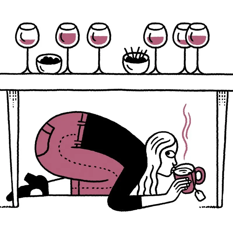 A woman drinking tea under a table of wine glasses.