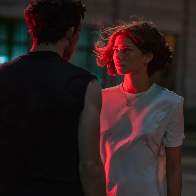 A woman standing in red light.