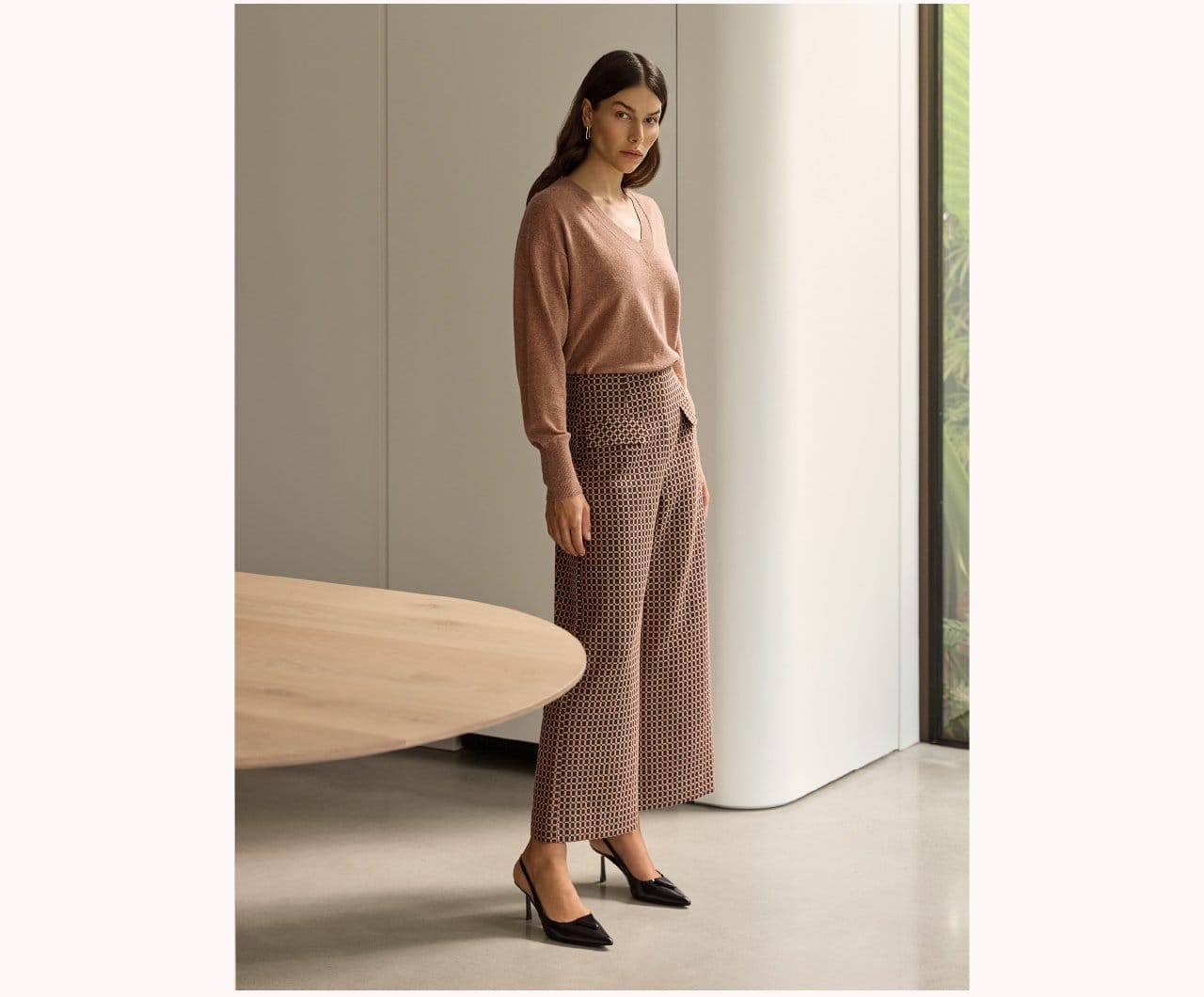 The model is wearing Deco Check Cropped Pants paired with Cashmere Merino Blend V-Neck Sweater